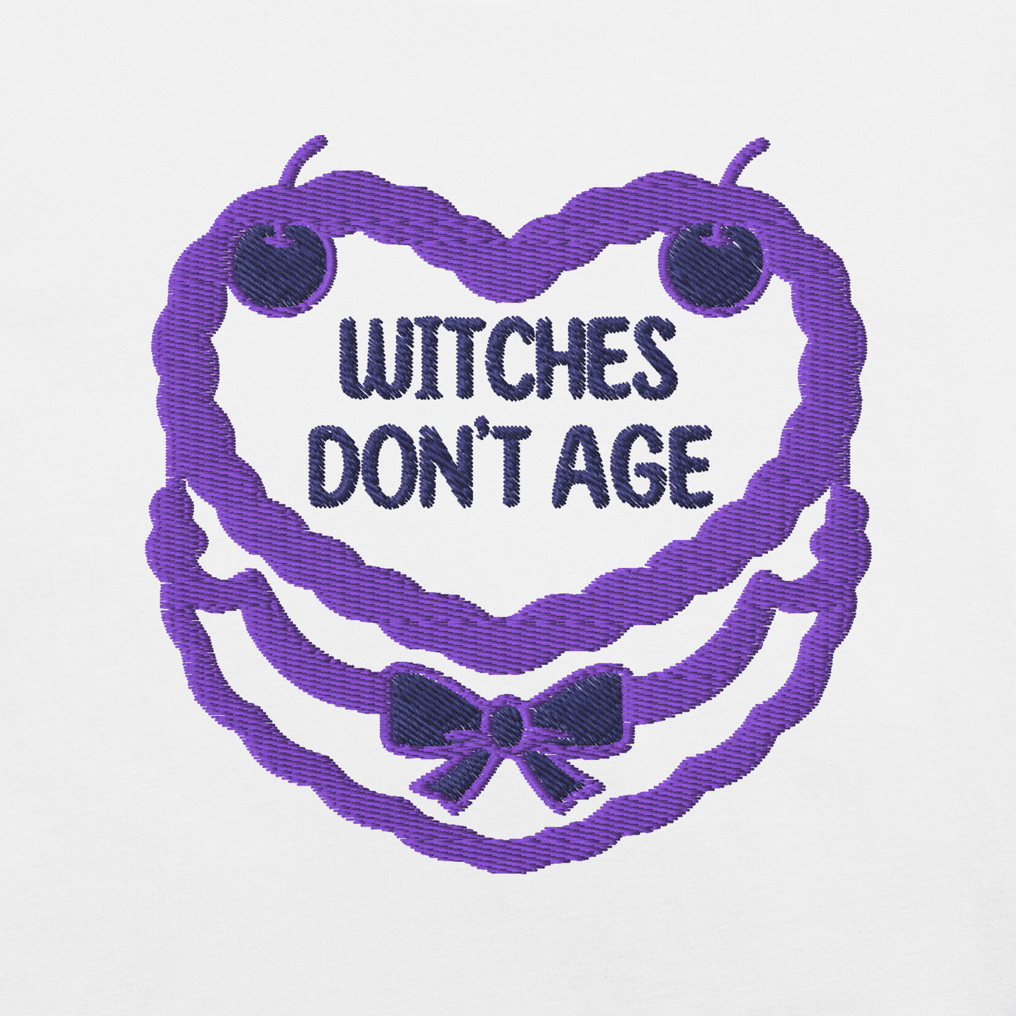 Ricamo di una maglietta con la scritta "Witches don't age" in un design festoso e colorato.