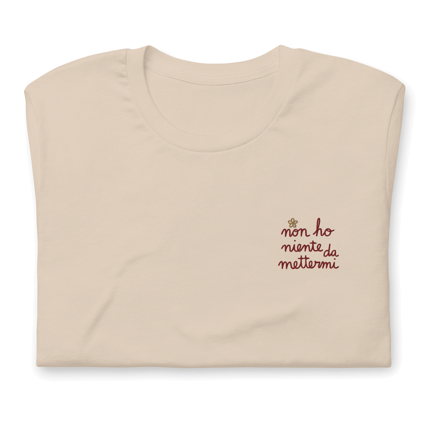 Maglietta ricamata da donna con la scritta "non ho niente da mettermi" su sfondo beige.