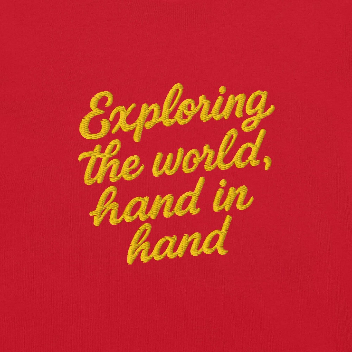 T-shirt giapponese da donna con frase ricamata "Exploring the world, hand in hand" su sfondo rosso.