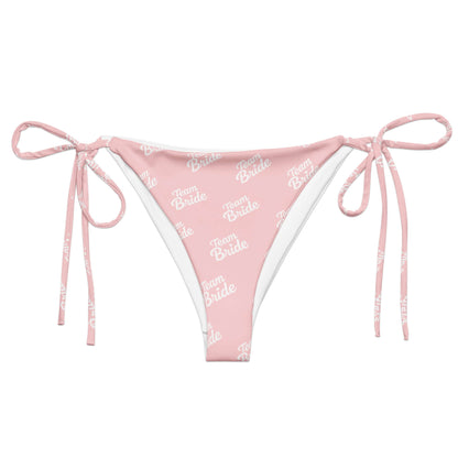 Slip bikini rosa con scritta 'Team Bride' in bianco e lacci, ideale per festeggiare l'addio al nubilato.