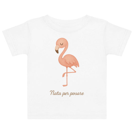 Vista frontale della t-shirt neonato bianca con illustrazione di un fenicottero e scritta “Nata per posare” sul petto.
