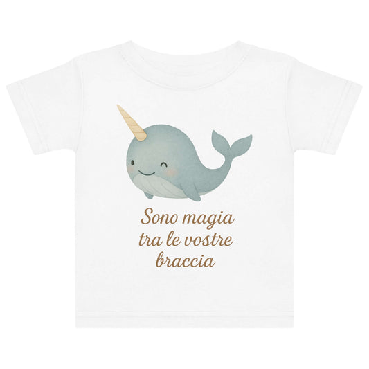 Vista frontale della t-shirt neonato bianca con illustrazione di un narvalo e scritta “Sono magia tra le vostre braccia” sul petto.