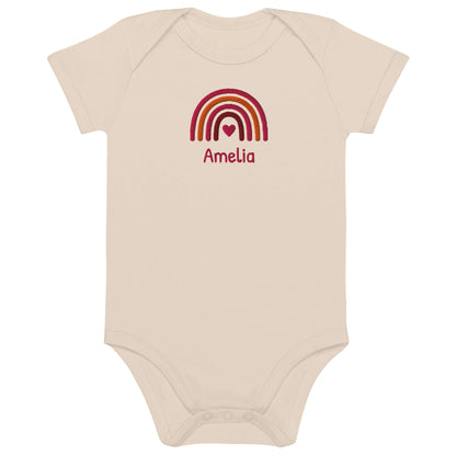 Body neonato personalizzato con arcobaleno ricamato e nome Amelia, in cotone organico.