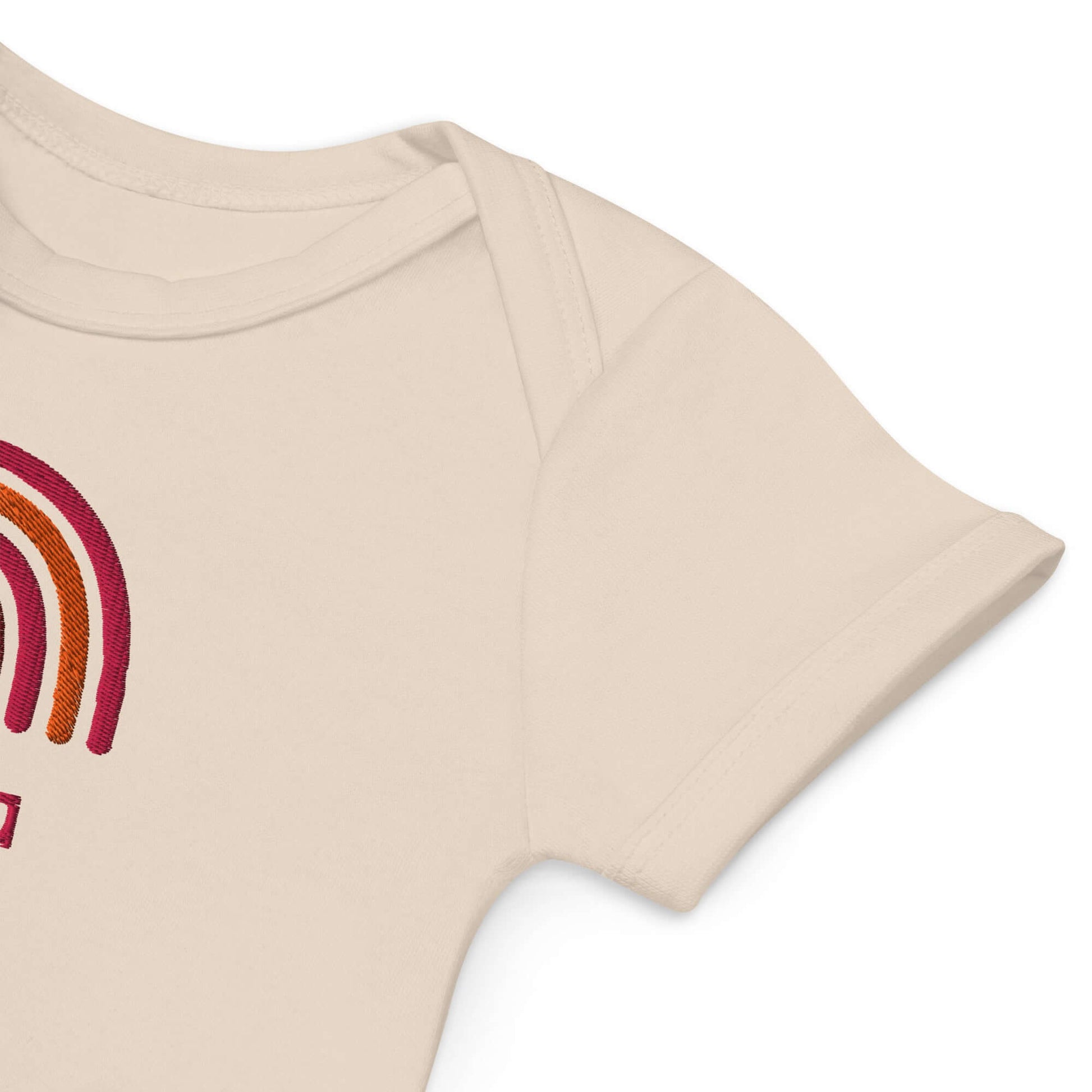 Dettaglio di body neonato personalizzato con arcobaleno ricamato in cotone organico per bimba.