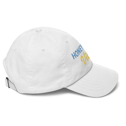 Cappellino unisex Honeymoon Vibes con ricamo colorato su sfondo bianco, ideale per look romantici e casual.