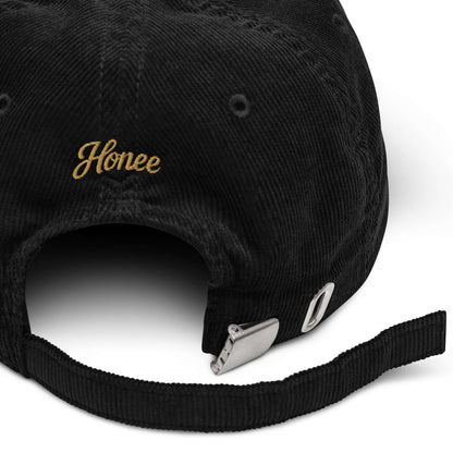 Cappellino ricamato in velluto a coste con scritta 'Honée' sul retro, ideale per look casual e chic.