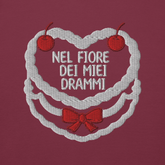 Ricamo 'Nel fiore dei miei drammi' su felpa color prugna, con cuori e ciliegie decorative.