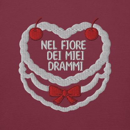 Ricamo 'Nel fiore dei miei drammi' su felpa color prugna, con cuori e ciliegie decorative.
