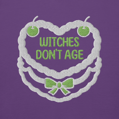 Ricamo felpa compleanno 'Witches don't age' su sfondo viola, design divertente e dark.