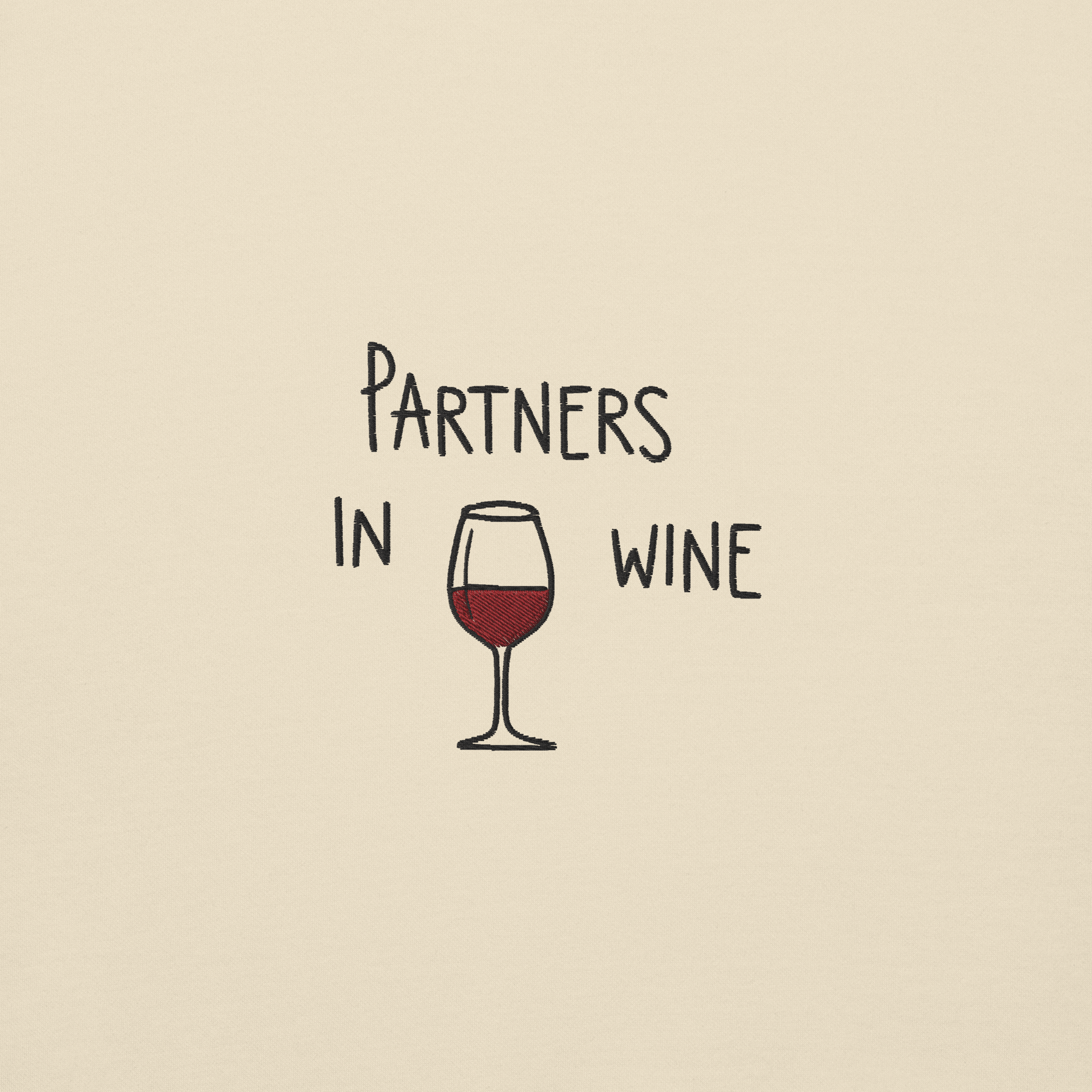 Ricamo con scritta 'Partners in Wine' e bicchiere di vino rosso su sfondo beige.