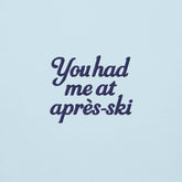 Scritta ricamata su felpa azzurra: "You had me at après-ski" in stile elegante e divertente.