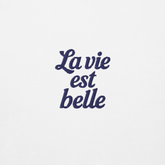 Ricamo blu su sfondo bianco con la scritta "La vie est belle" per la felpa viaggio ricamata Paris.