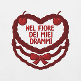 Ricamo t-shirt con scritta 'Nel fiore dei miei drammi' su sfondo bianco, dettagli in rosso.