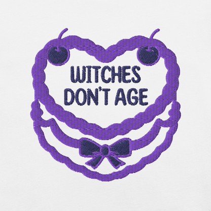 Ricamo di una maglietta con la scritta "Witches don't age" in un design festoso e colorato.