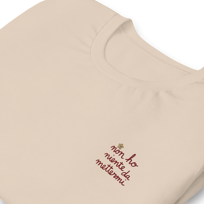 Maglietta ricamata da donna con la frase 'non ho niente da mettermi' su sfondo beige.