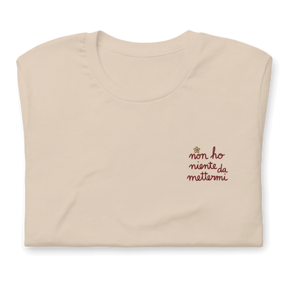 Maglietta ricamata da donna con la scritta "non ho niente da mettermi" su sfondo beige.