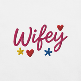 Ricamo 'Wifey' su t-shirt bianca con cuori e stelle colorate, ideale per la moglie.