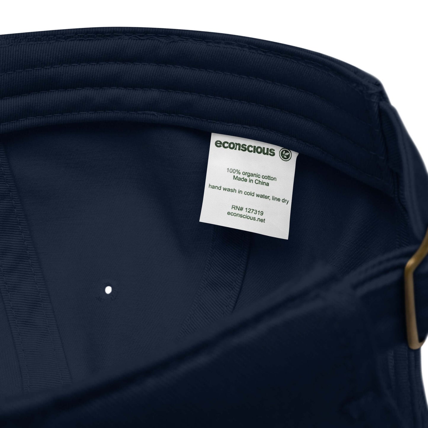 Etichetta interna di un cappellino ricamato in tessuto organico, evidenziando la composizione e le istruzioni di lavaggio.