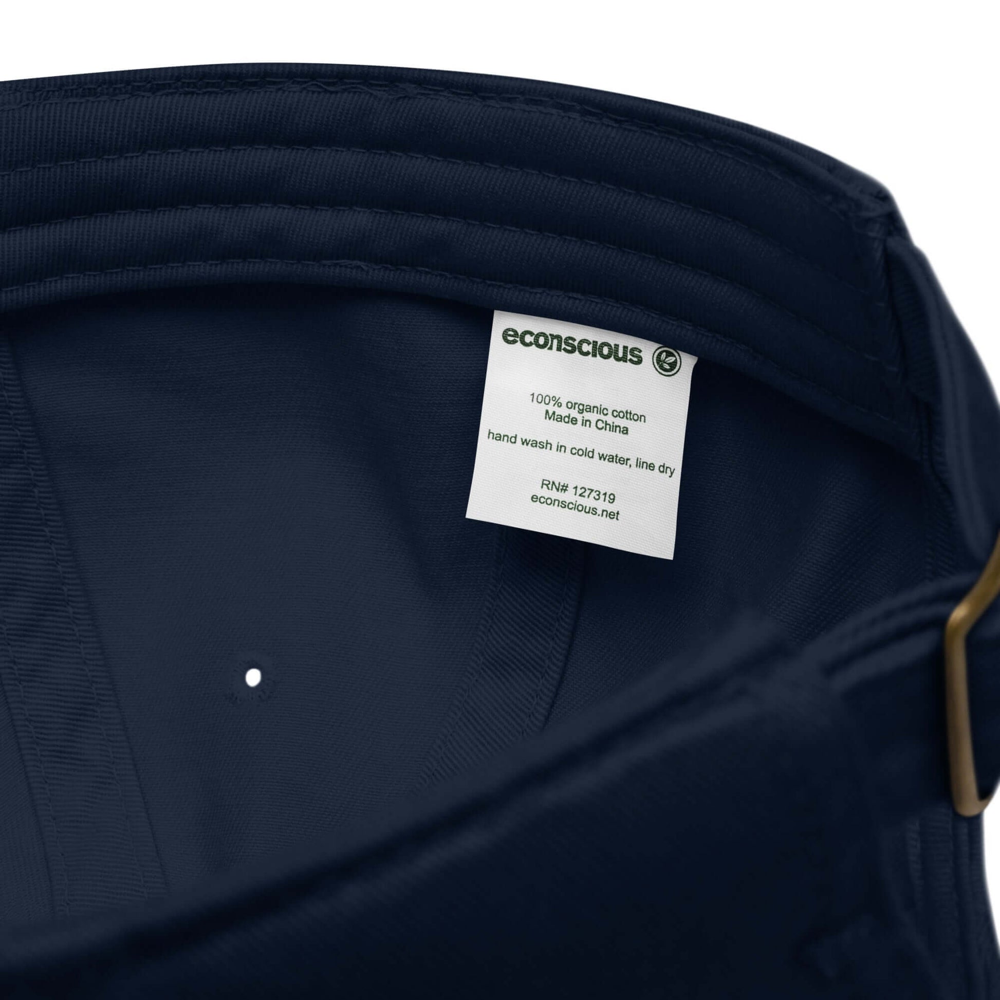 Etichetta interna di un cappellino ricamato in tessuto organico, evidenziando la composizione e le istruzioni di lavaggio.
