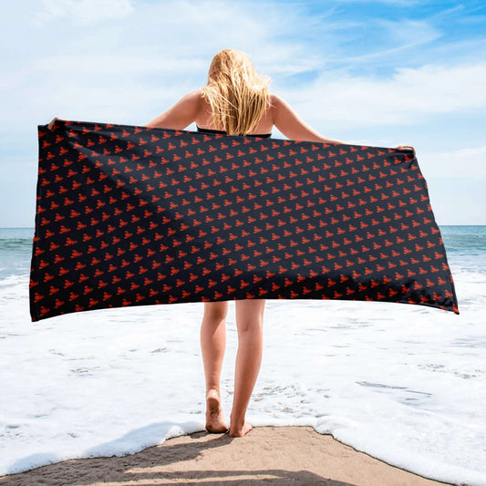 Telo mare con pattern di aragoste, ideale per coppie, in riva al mare con cielo azzurro.