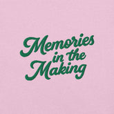 Ricamo della frase "Memories in the Making" su t-shirt rosa, ideale per le vacanze.