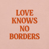 Ricamo su t-shirt Las Vegas con la frase 'Love Knows No Borders', in arancione su sfondo rosa.