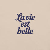 Ricamo della scritta 'La vie est belle' su t-shirt vacanze da donna, stile romantico e leggero.