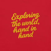 T-shirt giapponese da donna con frase ricamata "Exploring the world, hand in hand" su sfondo rosso.
