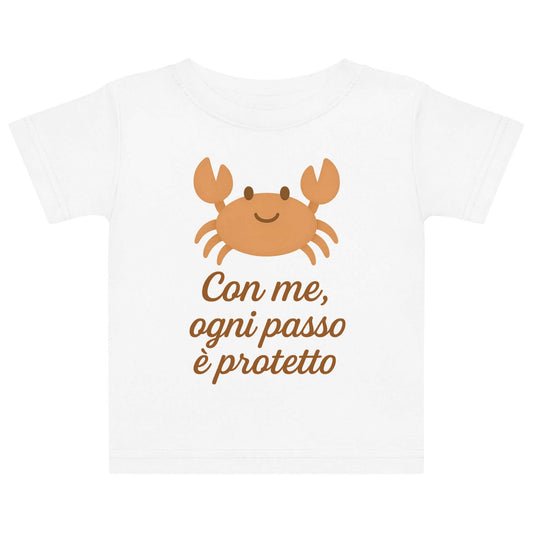 Vista frontale della t-shirt neonato bianca con illustrazione di un granchio e scritta “Con me, ogni passo è protetto” sul petto.