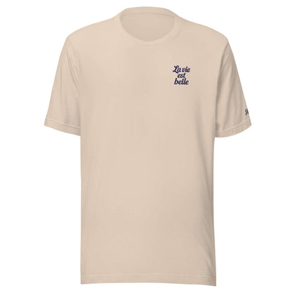T-shirt da donna beige con ricamo 'La vie est belle', ideale per viaggi e look estivi.