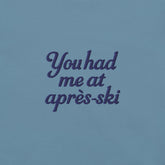 T-shirt uomo con ricamo 'You had me at aprés-ski' in blu su sfondo celeste, perfetta per appassionati di montagna.
