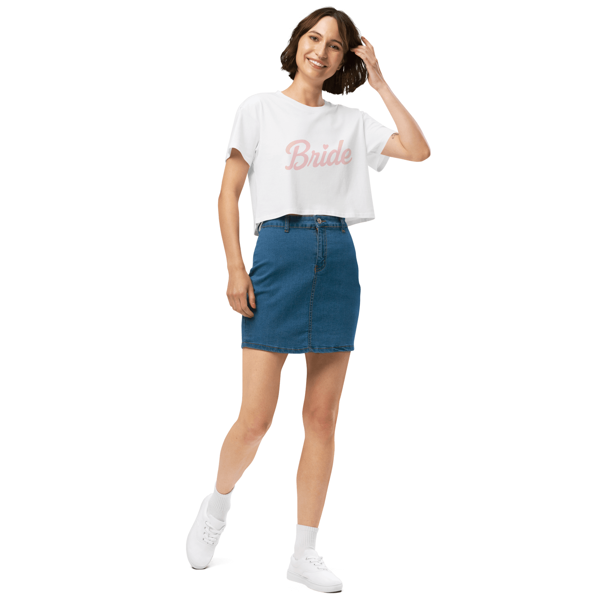 Crop top bianco con stampa 'Bride' indossato da una donna sorridente, abbinato a una gonna di jeans.